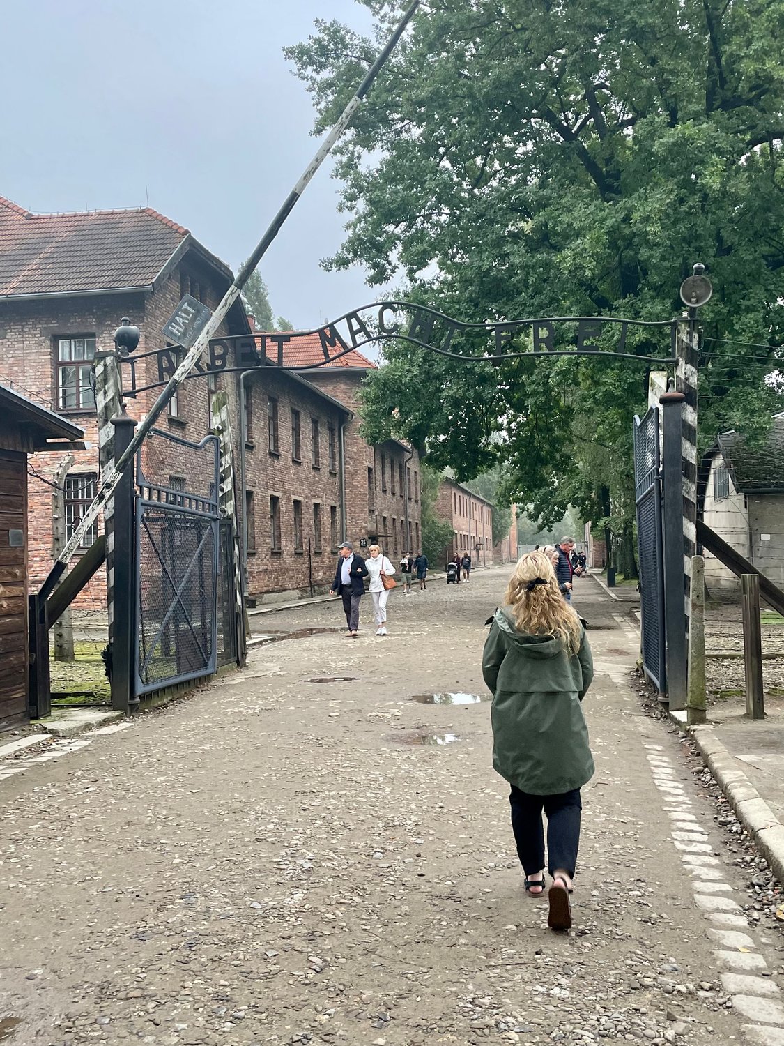 Helias Catholic teacher Sarah Kempker walks under the infamous “Arbeit macht frei” gate of Auschwitz I, which was in German-occupied Poland in World War II.